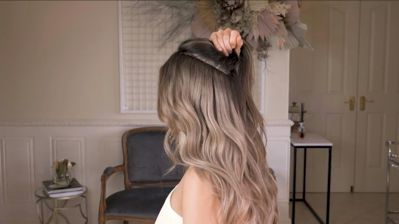 Mujer de espaldas con ondas suaves en tono rubio beige